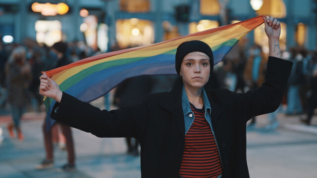 Young woman on the protest waving rainbow flag. Demonstrations during covid-19 outbreak and demand for equal rights. High quality photo