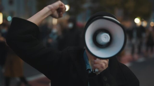 A young girl in a medical mask speaks through a loudspeaker. Protest against abortion, protecting womens right. High quality 4k footage