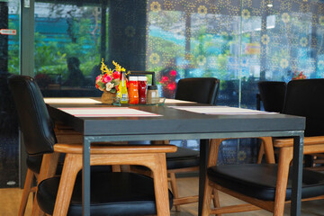An empty dining table with place mats and chairs.