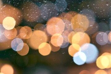 rainy drops water on window evening blurred blue yellow light reflection rain template textured...