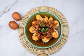 Fried egg with tamarind sauce or Sweet and Sour Eggs topped with fried onions and dried chilies. Thai food / Select focus