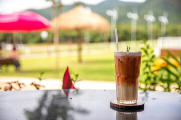Closeup Thai tea or iced tea on wood table in cafe in nature background