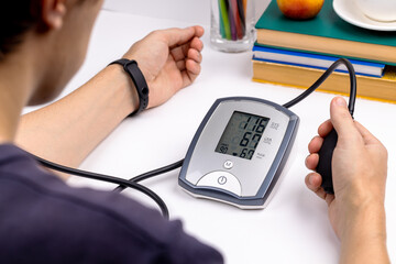 caucasian male person self check blood pressure using electronic tonometer. hypertension problem...