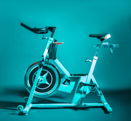 Vélo d'entrainement sur fond uni et lumière bleu