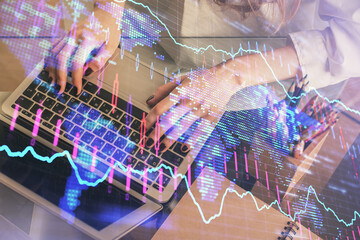 Double exposure of woman hands typing on computer and forex chart hologram drawing. Stock market...