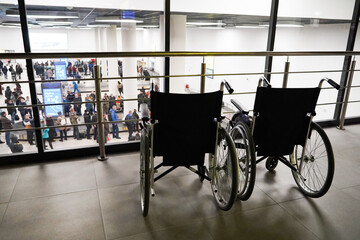 Fototapeta na wymiar two wheelchairs at the airport, a waiting room, assistance to people with limited mobility and people with disabilities 