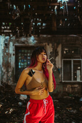 Fototapeta na wymiar Girl Smoking, construction, ruins, darkness, tattoo, smoke, Asian, red hair, top, underwear, Chernobyl, construction 