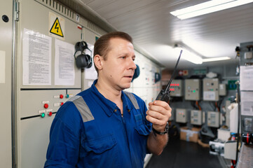 Marine Engineer working on radio communication at Engine Control room ECR. Vessel communication...