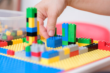 Hand picked jigsaw puzzle plastic building blocks on toy table.