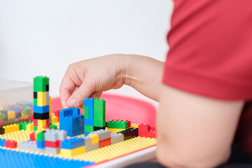 Hand picked jigsaw puzzle plastic building blocks on toy table.