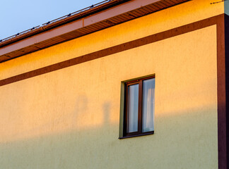 Wall of a stone house with one window.