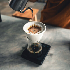 Drip coffee, barista pouring water on coffee ground with filter