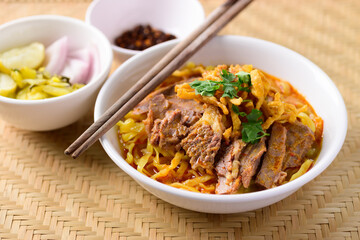 Northern Thai food (Khao Soi), Spicy curry noodles soup with beef eating with pickled mustard, shallot, lime and ground chili fried in oil