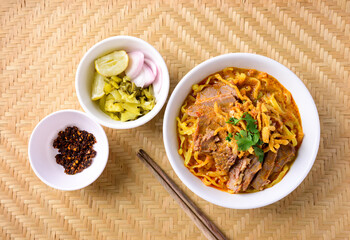 Northern Thai food (Khao Soi), Spicy curry noodles soup with beef eating with pickled mustard, shallot, lime and ground chili fried in oil