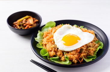 Korean food, Kimchi fried rice with fried egg on top and fresh kimchi cabbage