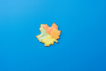 Sweet homemade leaf cookie with icing isolated on dark blue background minimal flat lay composition.