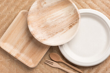 Betel palm leaf plate (Biodegradable, Compostable or Eco friendly disposable plate) on woven bamboo sheet, sustainable concept