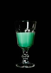 Goblet of absinthe on black background. Glass with absinth