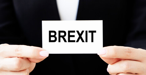 The businessman holds a business card with the text of BREXIT.