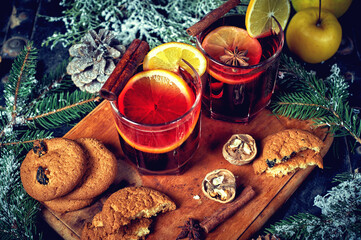 Mulled wine in a glass glass with fruit on a dark background, top view