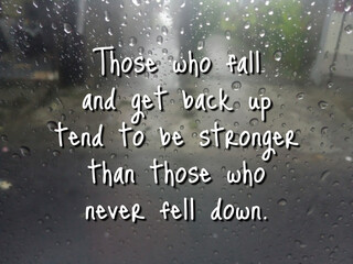 Inspirational motivational quote - Those who fall and get back up tend to be stronger than those who never fell down. Words of wisdom on background of rain drops on the window. Never give up concept. - obrazy, fototapety, plakaty