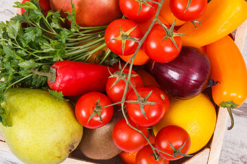 Fruits with vegetables in wooden box as healthy snack or dessert containing natural vitamins