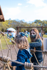 Família se divertindo em parque após reabertura devido a pandemia. Usando máscara. 