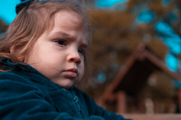 Retrato do rosto de uma garotinha com a cara brava. Menina séria.