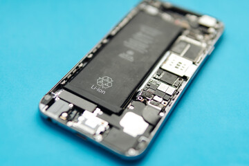 Disassembled phone on blue background. Selective focus.