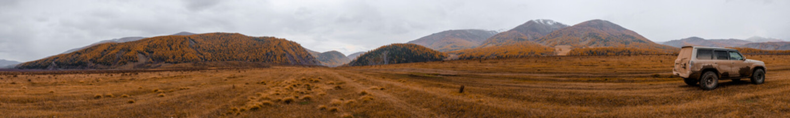Dirty offroad suv on mountain valley background in autumn. Offroad journey travel in autumn concept. Old Austrian road in East Kazakhstan. Travel in Kazakhstan concept. 22.09.2020 Katon, Kazakhstan. © Adil
