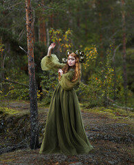 Fototapeta premium Forest creature: red headed girl with horns in green dress 