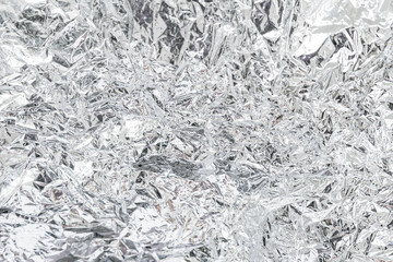 Silver rough wrinkle crumpled aluminum foil texture as a background
