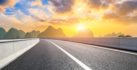 Country asphalt road and green mountain natural scenery in Guilin at sunrise,China.