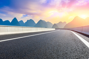 Country asphalt road and green mountain natural scenery in Guilin at sunrise,China.