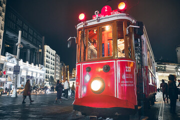 Vintage tram at Taksim Square in the rainy evening. Istanbul, Turkey - December 2019