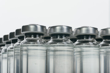 Glass medical ampoule vial for injection. Medicine is dry white drug penicillin powder or liquid with of aqueous solution in ampulla. Close up. Bottles ampule with aluminum cap on backgrounds gray.