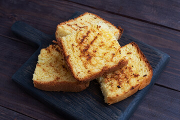 Slices toast wheat bread on a dark wooden background. Copy space.
