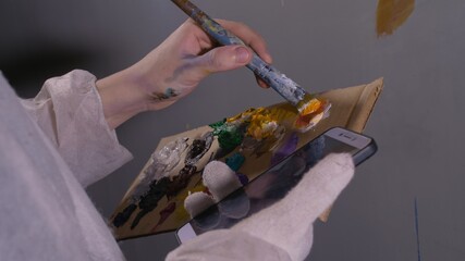 Artist designer draws an eagle on wall. Craftsman decorator paints picture with acrylic oil color...