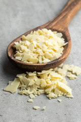 Grated white chocolate. Chocolate flakes in wooden spoon.