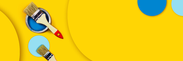 Abstract repair web-banner. One can of paint with paintbrushes on a yellow background with colored circles made from paper.