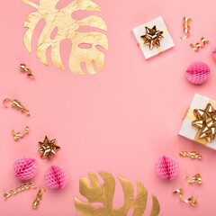 Golden tropical leaves Monstera, festive gift box, gold and pink decorations on amaranth pink background.
