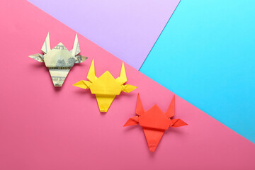 Origami bulls as symbol of year 2021 on color background