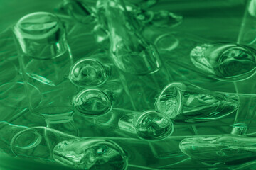 Glass medical ampoule vial for injection. Medicine is liquid sodium chloride with of aqueous solution in ampulla. Close up. Bottles ampule multicolor on background color and water. Human plasma.