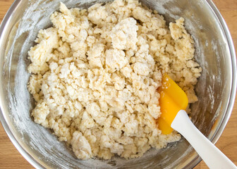 Ingredients with flour in a dough bowl. View from above