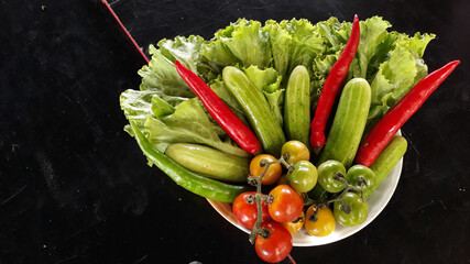 Colorful organic vegetables sourced from closed farms are healthy food. On a black background