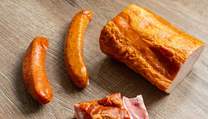 Lachs Kasslerbraten, Kochwurst und ein Stück Speck auf einem Holztisch