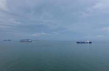 Cargo ships sailing through the cam, blue sea. 