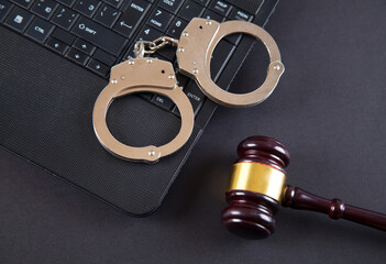 Judge gavel, police handcuffs and computer keyboard.