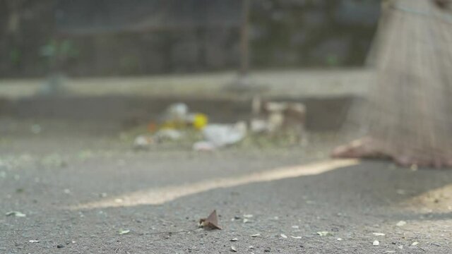 A man sweeps the street. Closeup shot street cleaning. Mumbai Maharashtra, India 