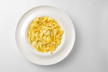 Delicious vegetarian dish of pasta with cheese served in a white plate over white background.